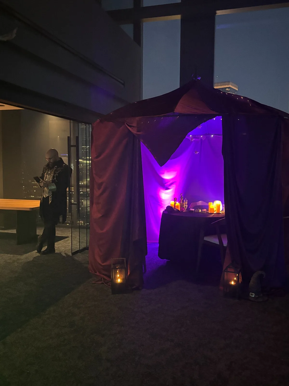 A purple-lit tarot tent set up at an evening event