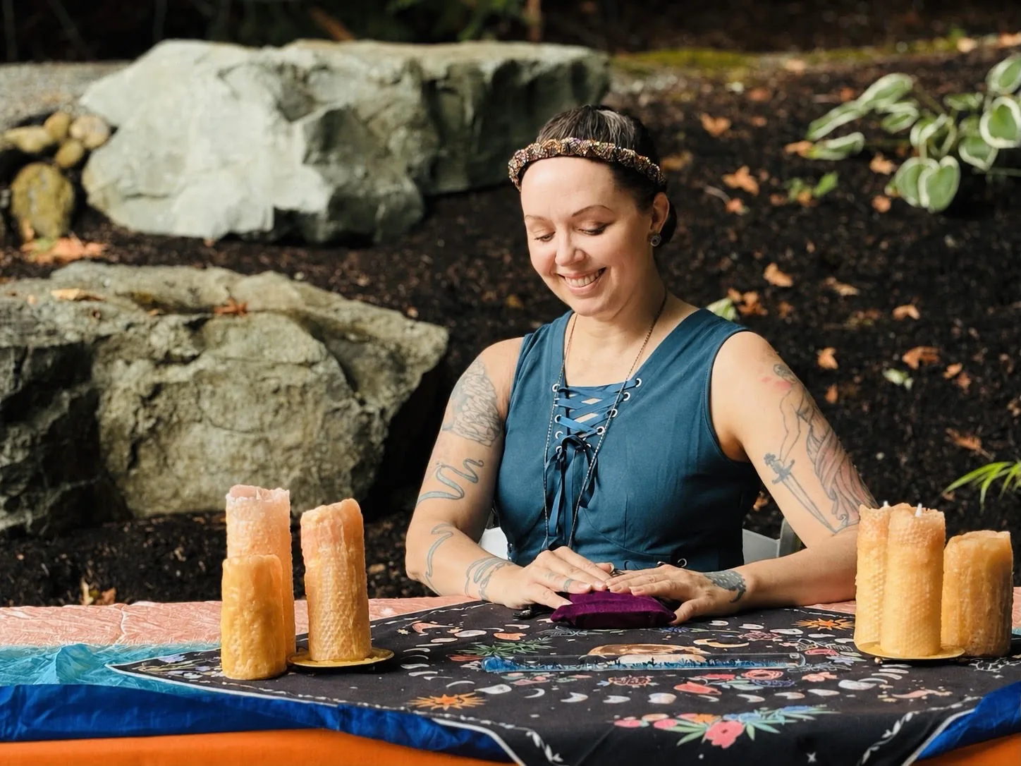 LoriLei seated behind a tarot table outdoors